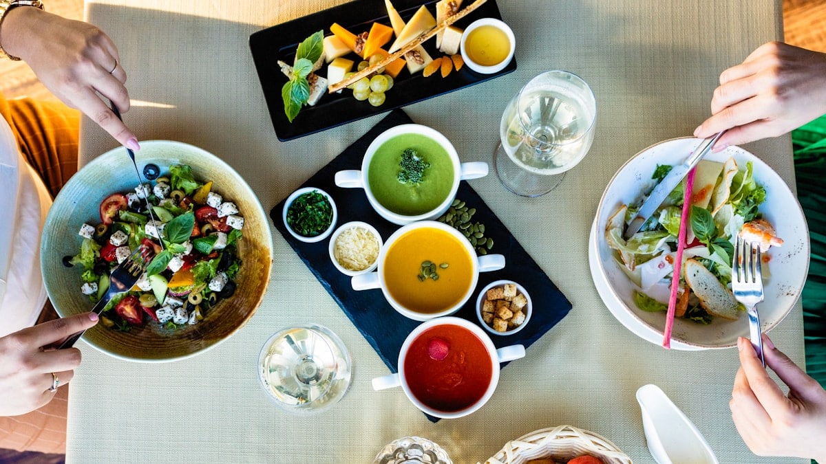 Eating cheese, chicken salad with different soups on the table
